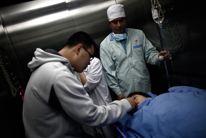 Một sản phụ đang được chồng động viên khi vượt cạn tại bệnh viện Ruijin, Thượng Hải, Trung Quốc.